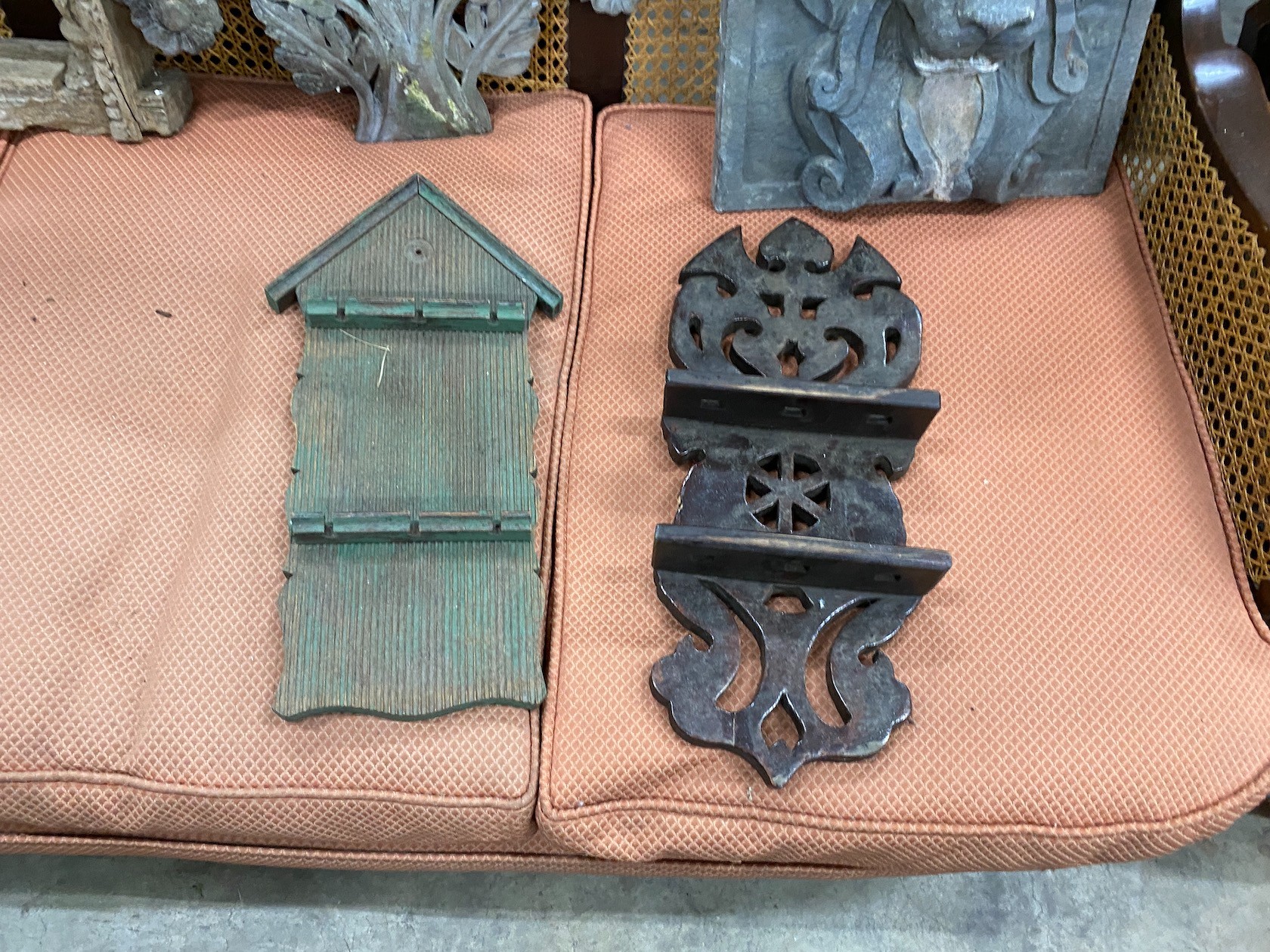 A carved Eastern hardwood window frame, height 82cm, a composition lion mask wall fountain two spoon racks and a composition wall hanging
